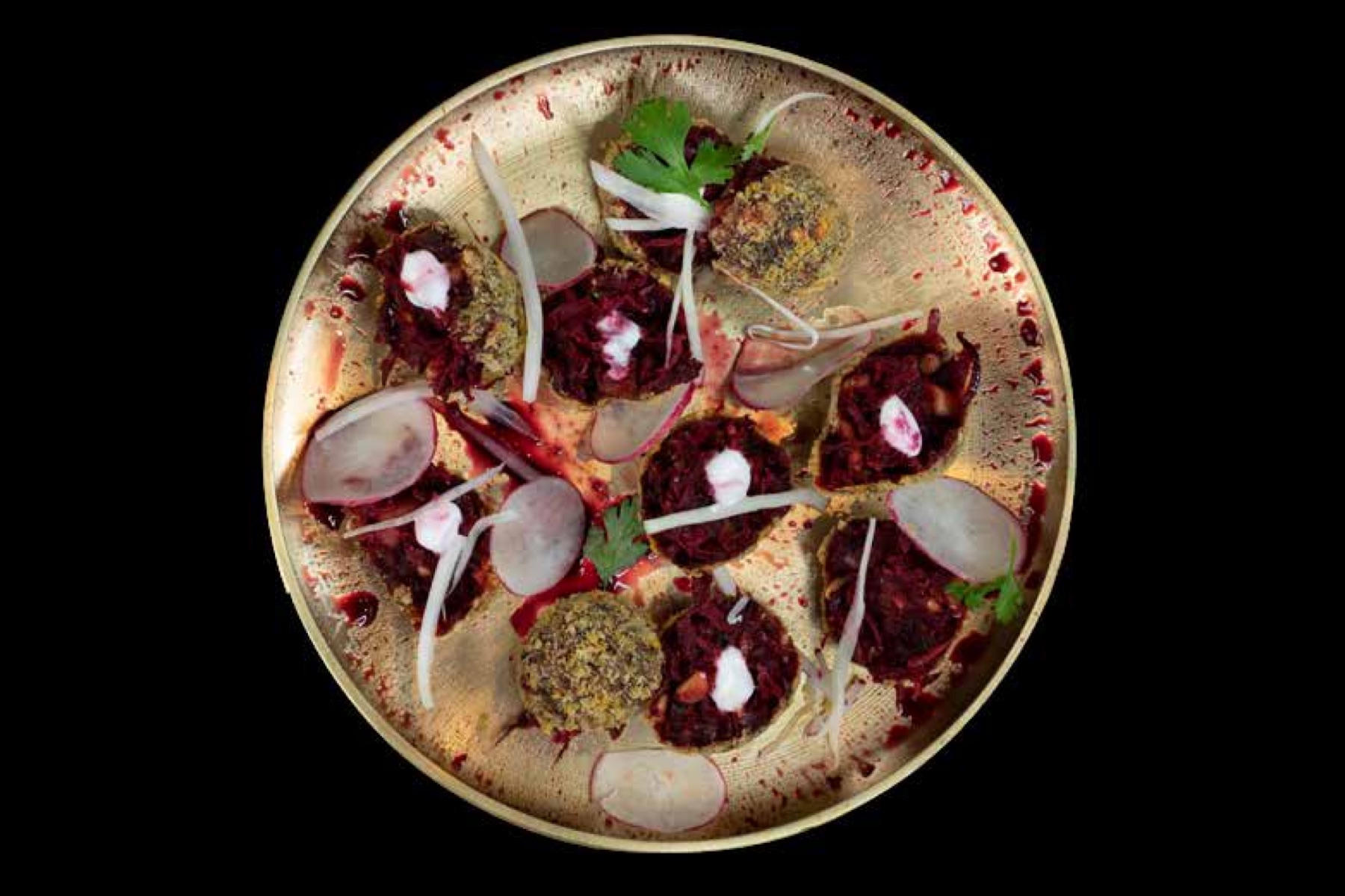 A modern Indian beetroot tikki plated on a brass thali at a live station