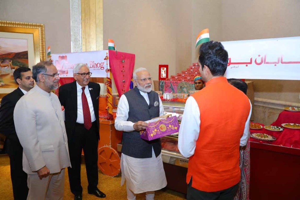 Prime Minister Narendra Modi receiving a box of handcrafted Chhappan Bhog sweets at Emirates Palace